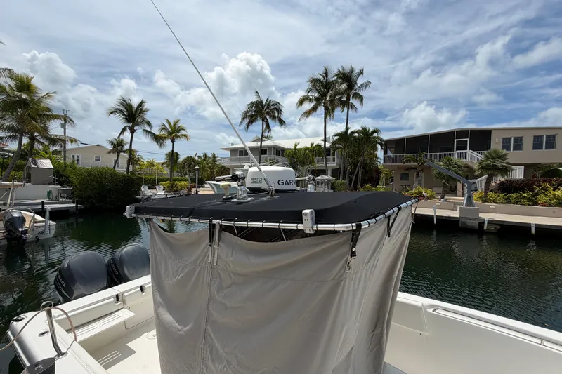 Slide: The Image of 2004 Triton 2895 CC boat docked by palm trees and waterfront homes. - 4