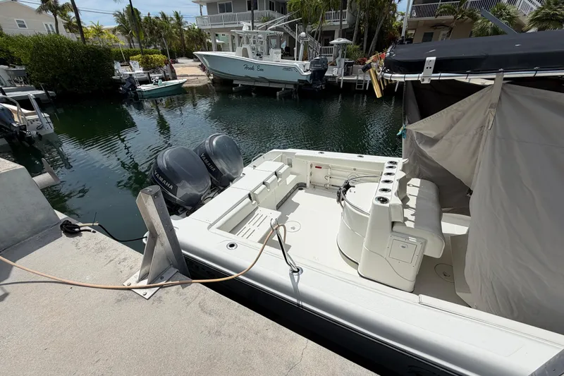 Slide: The Image of 2004 Triton 2895 CC boat docked with dual Yamaha engines in a serene marina setting. - 5