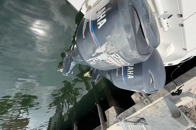 Slide: The Image of Twin Yamaha outboard motors on a 2004 Triton 2895 CC boat docked by the water. - 9
