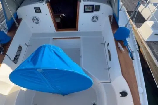Slide: The Image of 1985 Sabre 32 sailboat cockpit with blue cover, wooden trim, and open cabin entrance. - 29
