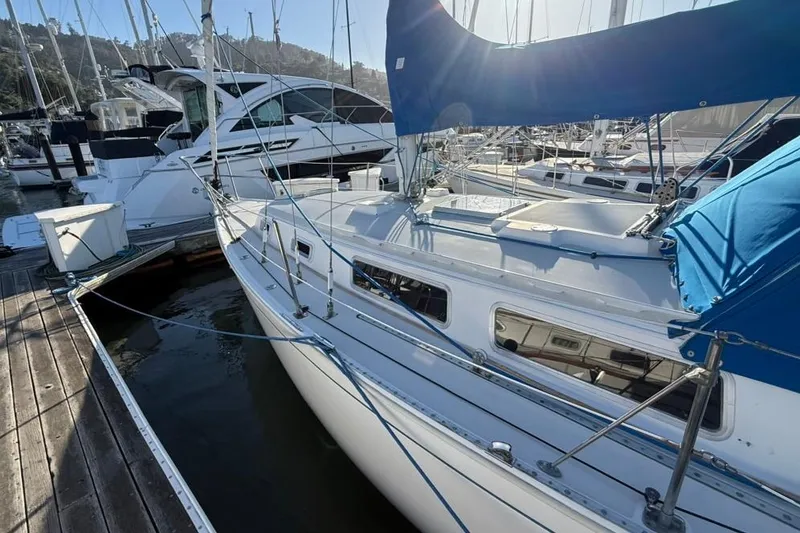 Slide: The Image of 1985 Sabre 32 sailboat docked at marina, featuring blue sail cover. - 31