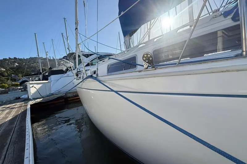 Slide: The Image of 1985 Sabre 32 sailboat docked in marina, sunlight reflecting on water. - 33
