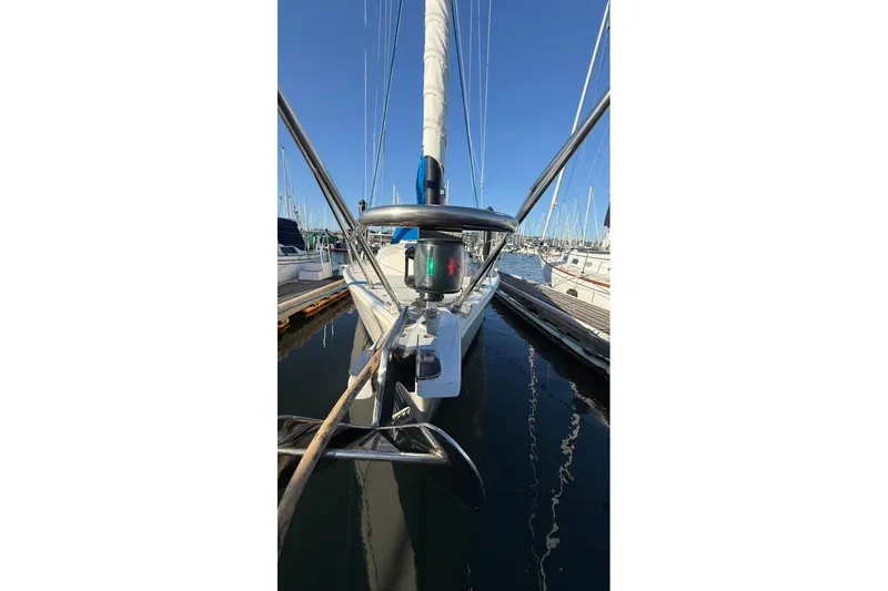 Slide: The Image of 1985 Sabre 32 sailboat docked at marina, featuring bow and rigging details. - 35