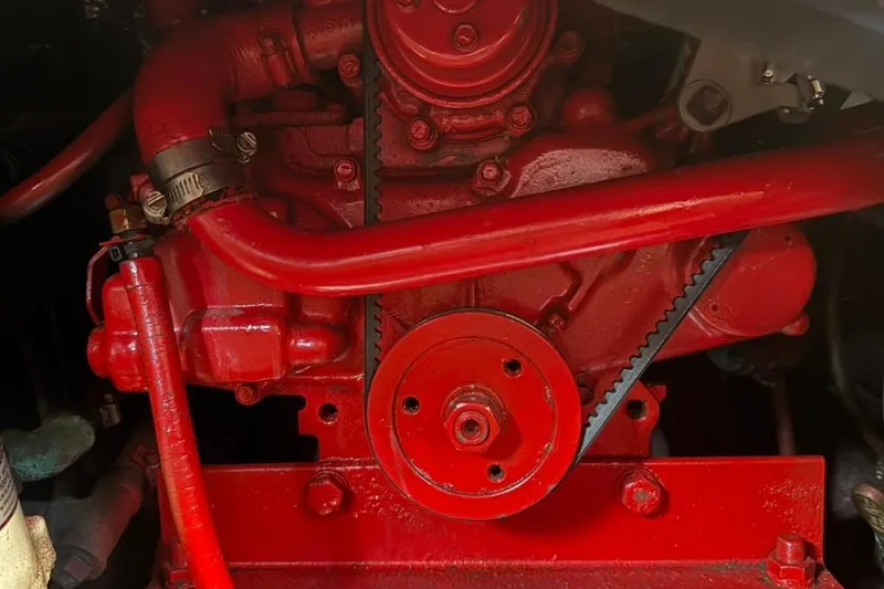 Slide: The Image of Red engine components of a 1985 Sabre 32, featuring belts and hoses. - 36