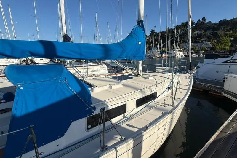 Slide: The Image of 1985 Sabre 32 sailboat docked in a marina, featuring blue covers and rigging. - 39