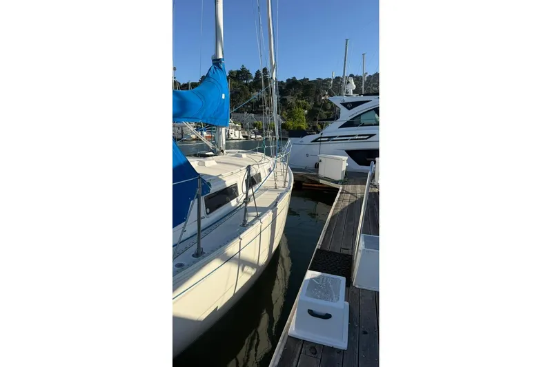 Slide: The Image of 1985 Sabre 32 sailboat docked at marina with blue sail cover. - 41