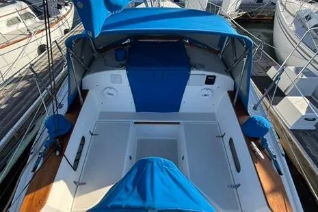 Slide: The Image of 1985 Sabre 32 sailboat cockpit with blue canopy and seating, docked at marina. - 7