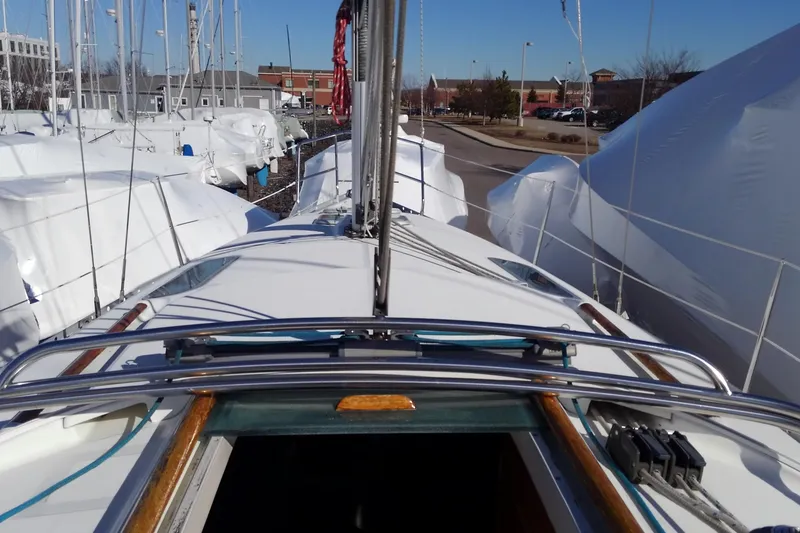 Slide: The Image of 1995 Beneteau Oceanis 321 sailboat docked, surrounded by covered boats in a marina. - 11