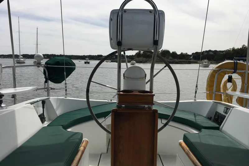 Slide: The Image of Cockpit view of a 1996 Beneteau Oceanis 321 sailboat, anchored in a serene harbor. - 12