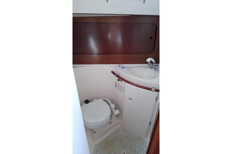 Slide: The Image of Bathroom interior of 1996 Beneteau Oceanis 321 sailboat, featuring compact toilet and sink. - 17