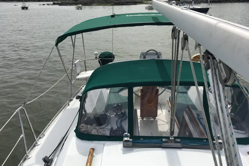 Slide: The Image of 1996 Beneteau Oceanis 321 sailboat with green canopy, docked in a calm harbor. - 3