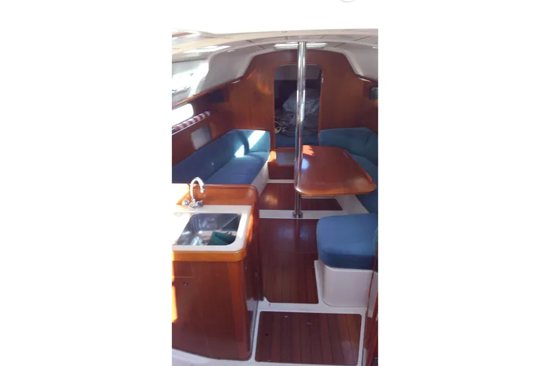 Slide: The Image of Interior of 1995 Beneteau Oceanis 321 sailboat with wood finish and blue seating. - 9