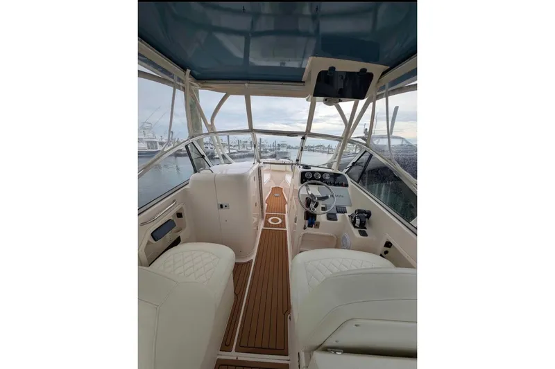 Slide: The Image of 2010 Grady-White Tournament 275 boat interior with helm, seating, and wood flooring. - 6