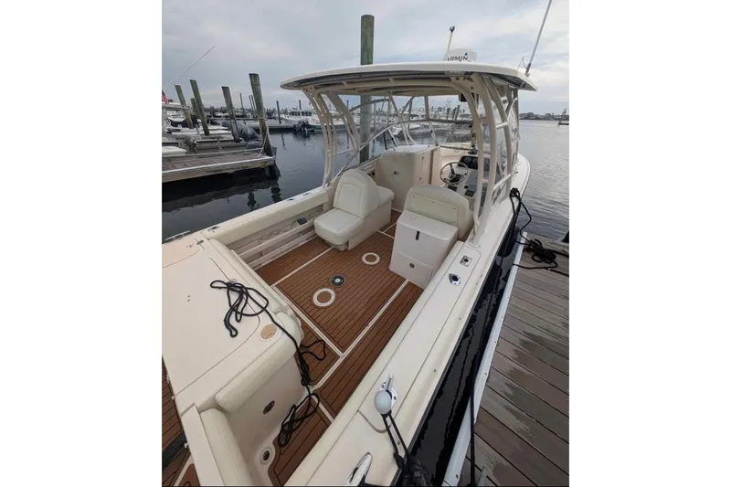Slide: The Image of 2010 Grady-White Tournament 275 boat docked, featuring spacious deck and seating. - 7