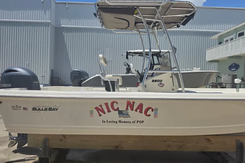 Slide: The Image of 2021 Bulls Bay 2200 boat named "Nic Nac" with Yamaha engine, docked outdoors. - 12
