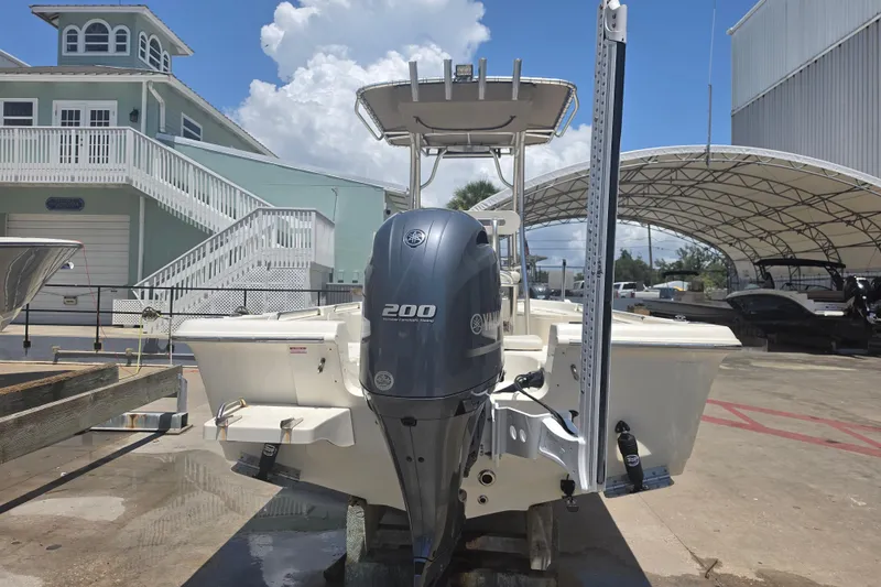 Slide: The Image of 2021 Bulls Bay 2200 boat with Yamaha 200 engine, docked near a coastal building. - 5