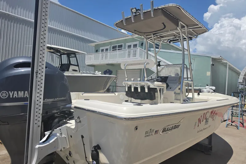 Slide: The Image of 2021 Bulls Bay 2200 boat with Yamaha engine, docked outdoors under a clear sky. - 6