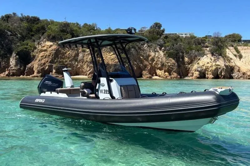 Slide: The Image of 2026 Brig Eagle 6.7 boat on clear turquoise water near rocky shoreline. - 10