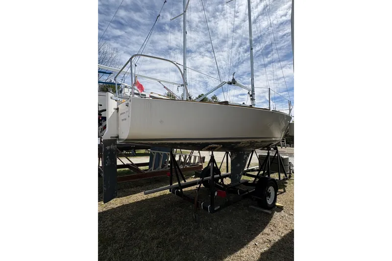 Slide: The Image of 1982 J Boats J/24 sailboat on trailer under a cloudy sky. - 5