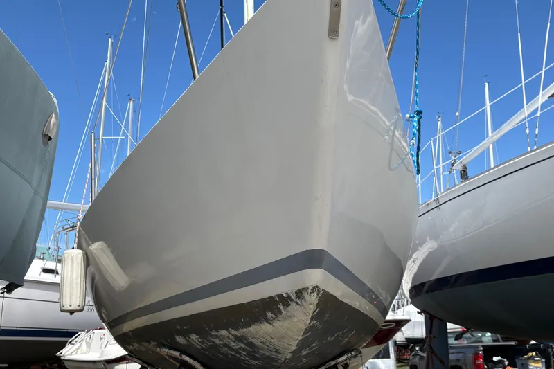 Slide: The Image of 1982 J Boats J/24 sailboat hull in dry dock, surrounded by other vessels. - 8