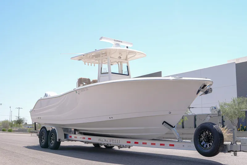The Image of 2024 NauticStar 292 Legacy boat on trailer, parked outdoors under clear sky. - 0