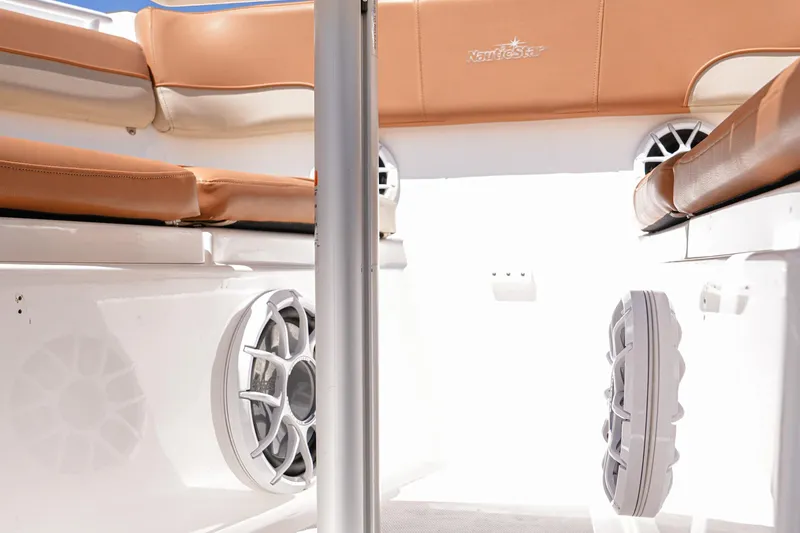 Slide: The Image of 2024 NauticStar 292 Legacy boat interior with tan seating and built-in speakers. - 21