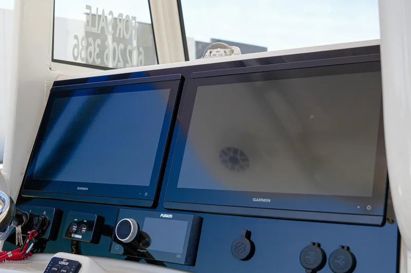 Slide: The Image of 2024 NauticStar 292 Legacy boat dashboard with dual Garmin displays. - 29