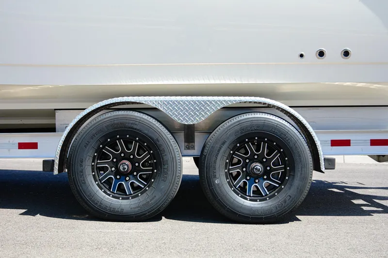 Slide: The Image of Trailer wheels of 2024 NauticStar 292 Legacy boat on a sunny day. - 36