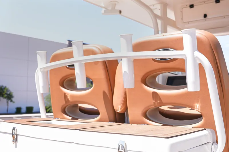 Slide: The Image of 2024 NauticStar 292 Legacy boat seats with rod holders, featuring tan upholstery and sleek design. - 6