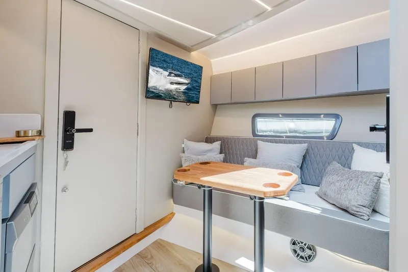 Slide: The Image of Modern interior of Hanover 415 yacht, featuring cozy seating, table, and wall-mounted TV, 2027 model. - 10