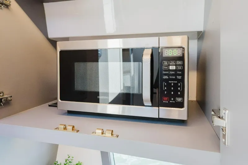 Slide: The Image of Modern Hanover 415 microwave in a sleek kitchen setting, year 2027 model. - 13