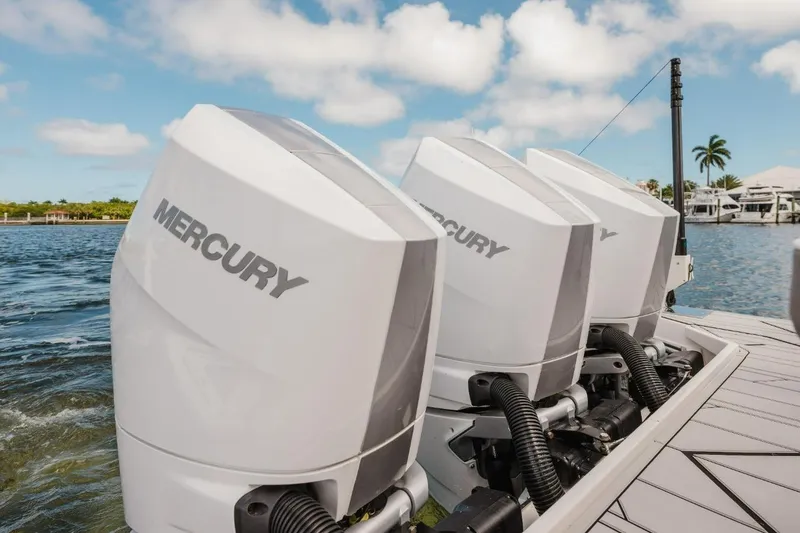 Slide: The Image of Triple Mercury outboard engines on a Hanover 415 boat, 2027 model, docked by the water. - 14