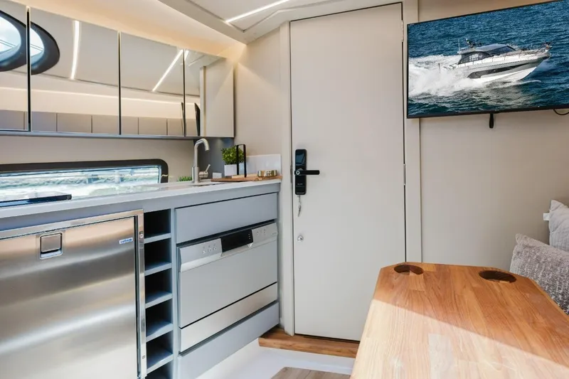 Slide: The Image of Modern interior of Hanover 415 yacht, featuring sleek kitchen and mounted TV, 2027 model. - 5