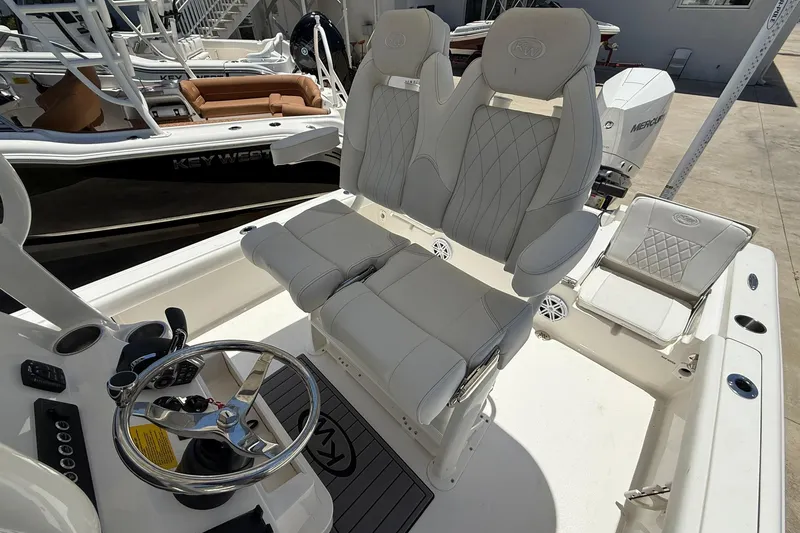 Slide: The Image of 2026 Key West 230 Bay Reef boat interior with dual captain's chairs and steering wheel. - 10