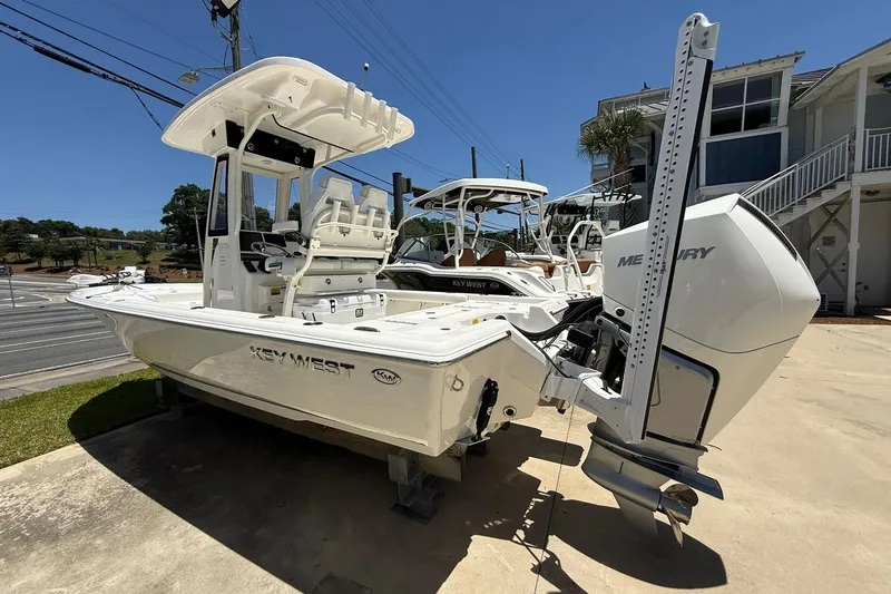 Slide: The Image of 2026 Key West 230 Bay Reef boat with Mercury engine, parked outdoors on a sunny day. - 2