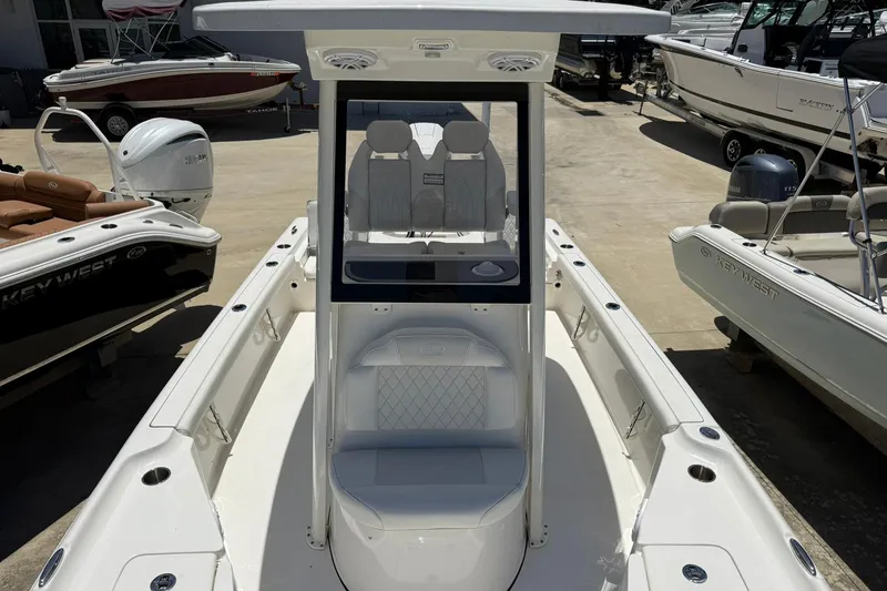 Slide: The Image of 2026 Key West 230 Bay Reef boat, white interior, docked among other boats. - 6