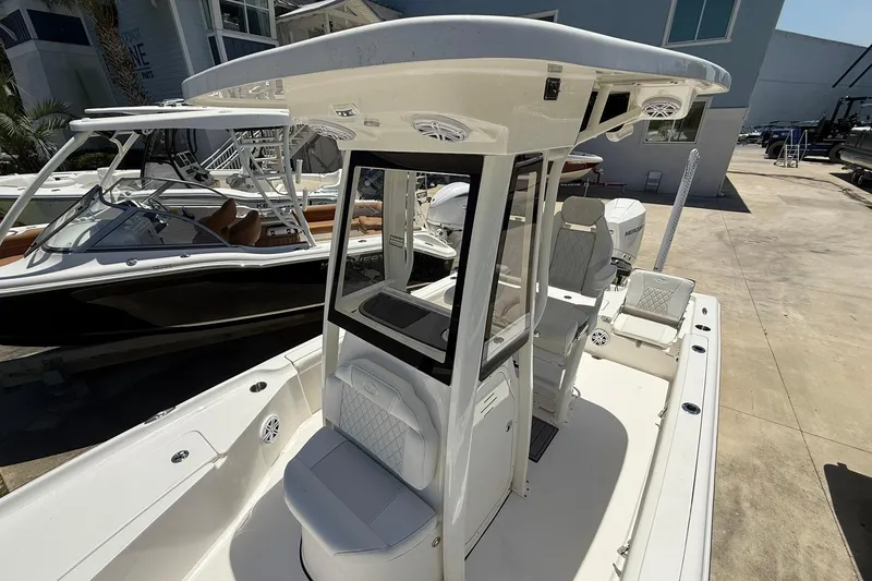 Slide: The Image of 2026 Key West 230 Bay Reef boat with T-top and seating, docked outdoors. - 7