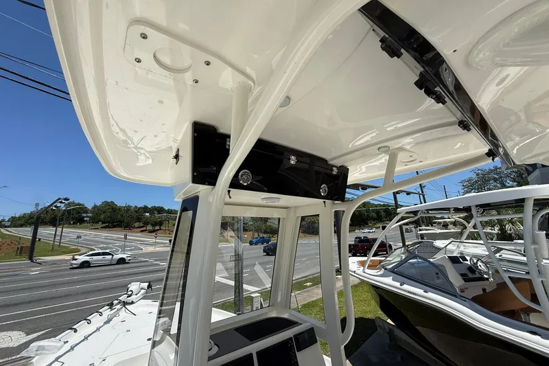 Slide: The Image of 2026 Key West 230 Bay Reef boat with T-top, parked near a busy intersection. - 8