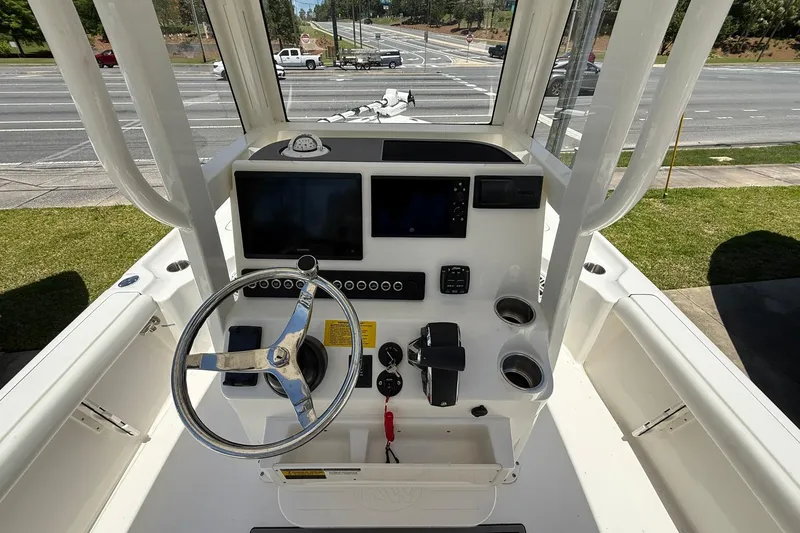 Slide: The Image of 2026 Key West 230 Bay Reef boat dashboard with steering wheel and navigation controls. - 9