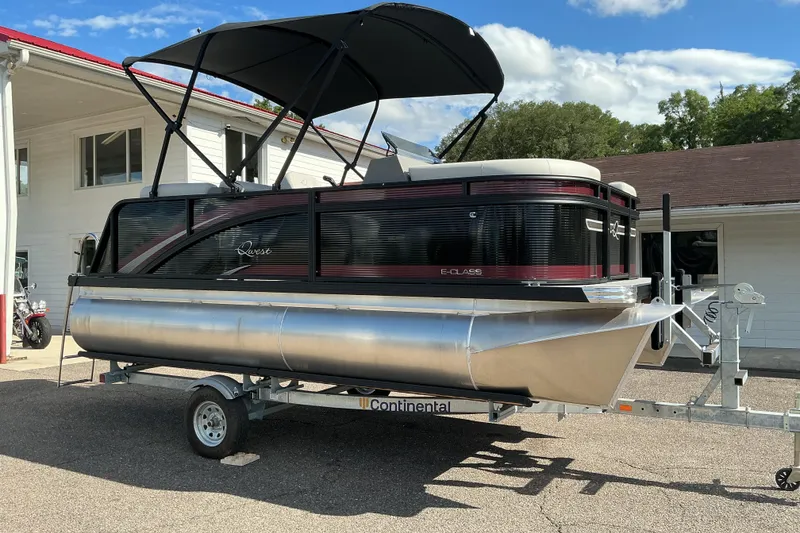 The Image of 2025 Qwest E-Class RLS 16 pontoon boat on trailer, parked outdoors. - 0