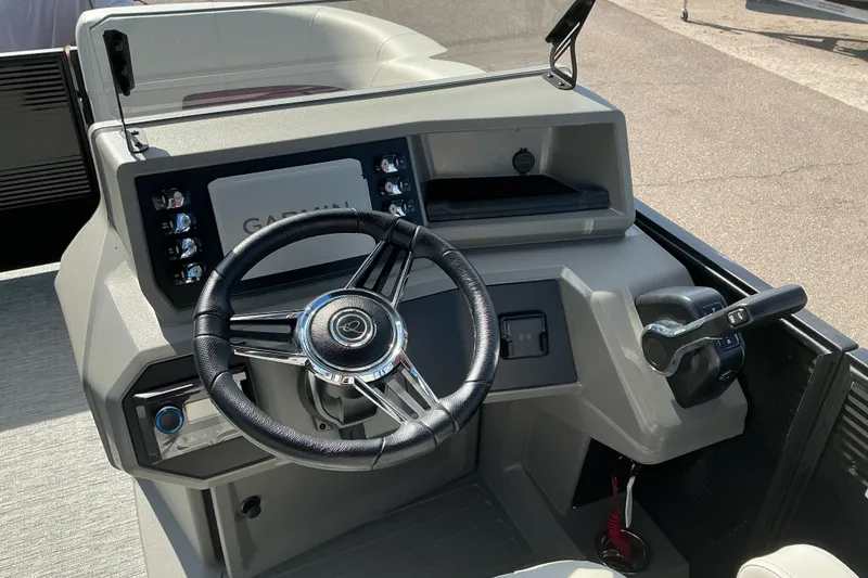 Slide: The Image of 2025 Qwest E-Class RLS 16 boat dashboard with steering wheel and Garmin display. - 12