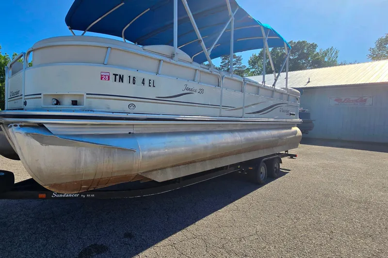 The Image of 2005 Lowe Jamaica 250SD pontoon boat on trailer with blue canopy in sunny setting. - 1