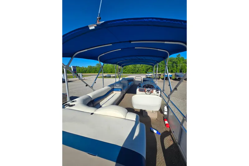 Slide: The Image of 2005 Lowe Jamaica 250SD pontoon boat with blue canopy and spacious seating. - 4