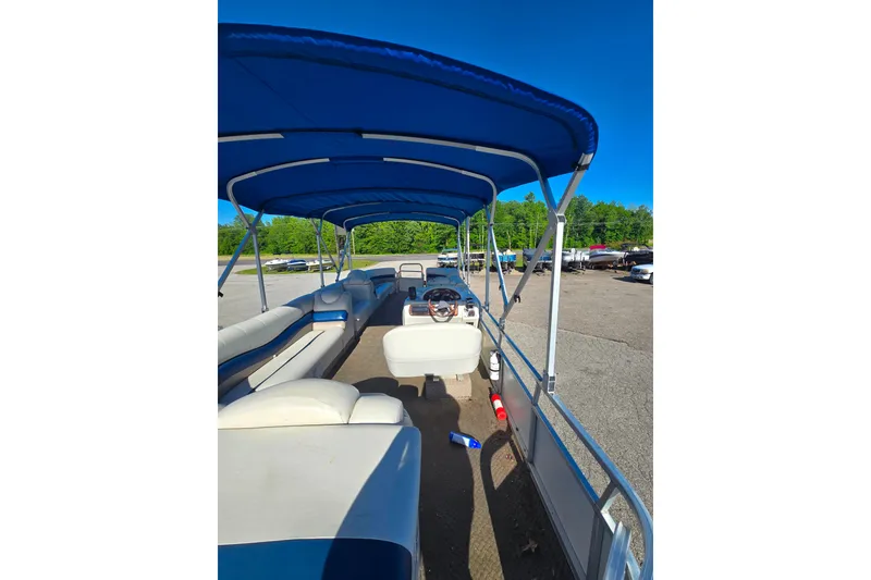 Slide: The Image of 2005 Lowe Jamaica 250SD pontoon boat with blue canopy, parked on a sunny day. - 5