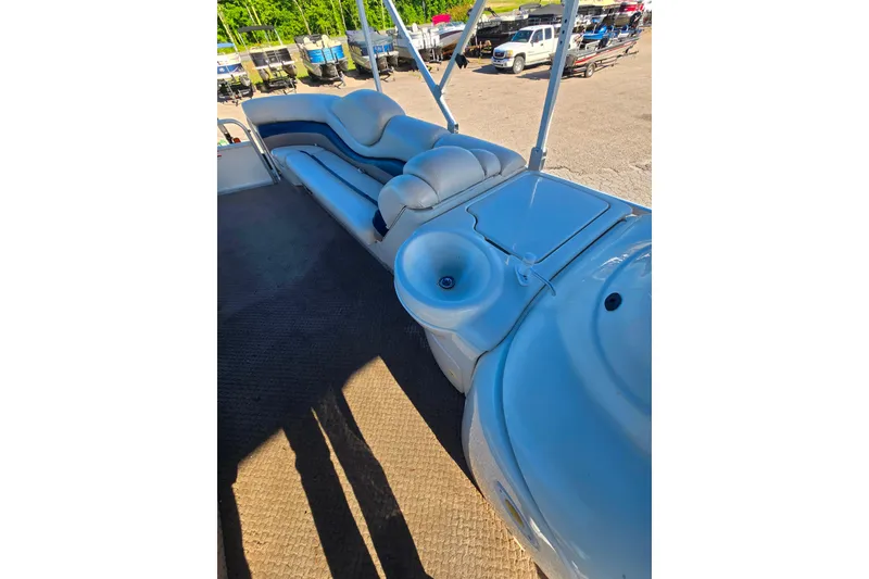 Slide: The Image of 2005 Lowe Jamaica 250SD boat interior with seating and sink, parked outdoors. - 9