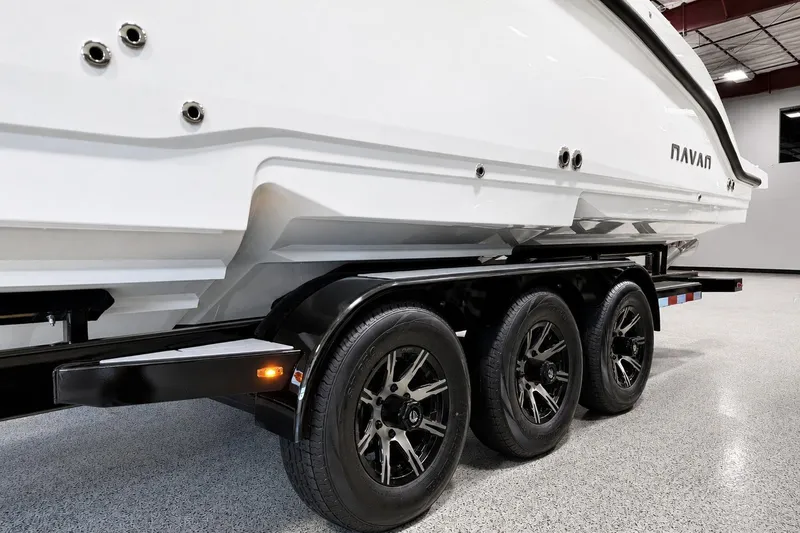 Slide: The Image of 2026 Navan S30 boat on a triple-axle trailer in a showroom setting. - 1