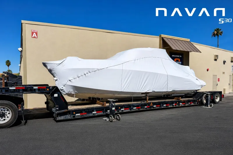 Slide: The Image of Covered Navan S30 boat on trailer, parked outside a building, 2026 model. - 9