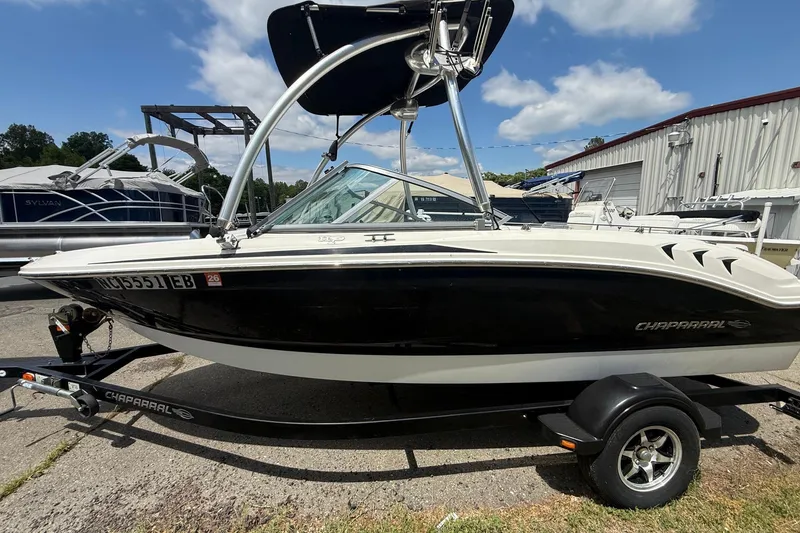 The Image of 2012 Chaparral 18 H2O Sport boat on trailer, parked outdoors under blue sky. - 1