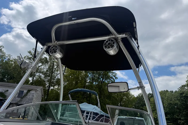 Slide: The Image of 2012 Chaparral 18 H2O Sport boat with canopy and speakers under a cloudy sky. - 10