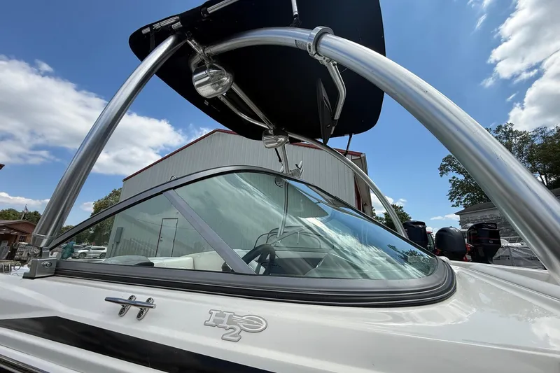 Slide: The Image of 2012 Chaparral 18 H2O Sport boat with sleek design and canopy under blue sky. - 9